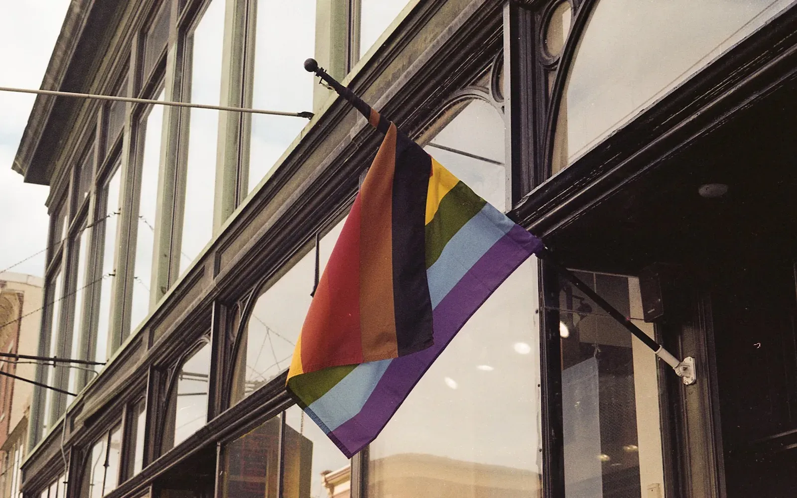 Progress-Pride-Flagge mit trans* Farben an einer Hausfassade – Trans Dating No-Gos
