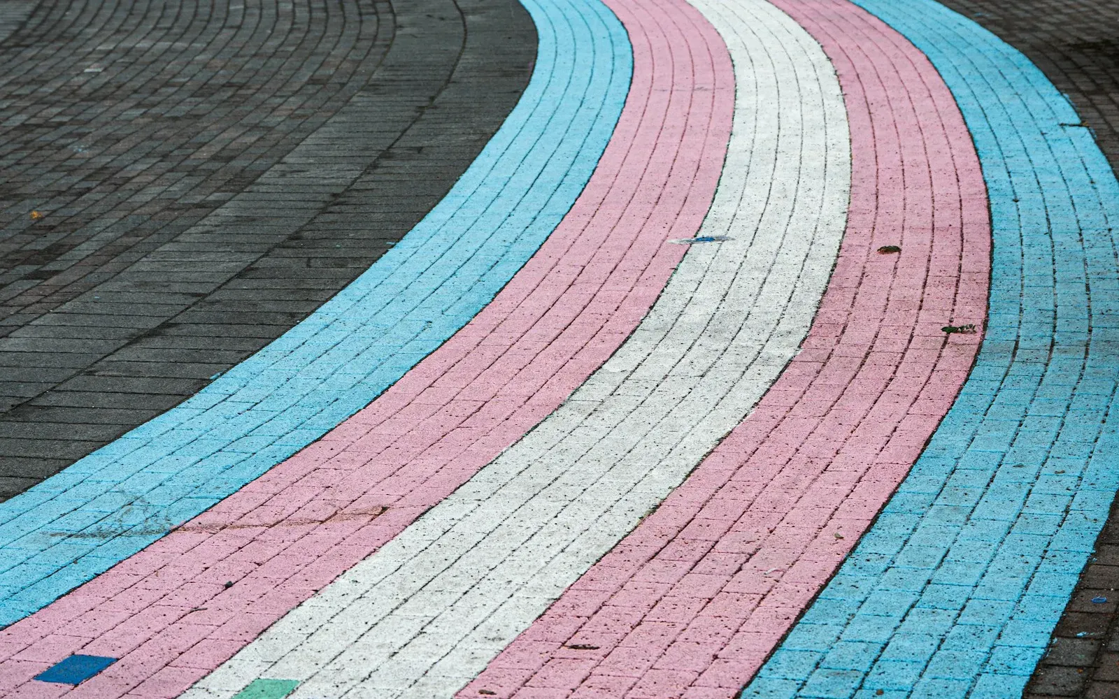 Gepflasterter Gehweg in den Farben der trans* Flagge: Hellblau, Rosa und Weiß – Trans Treffen